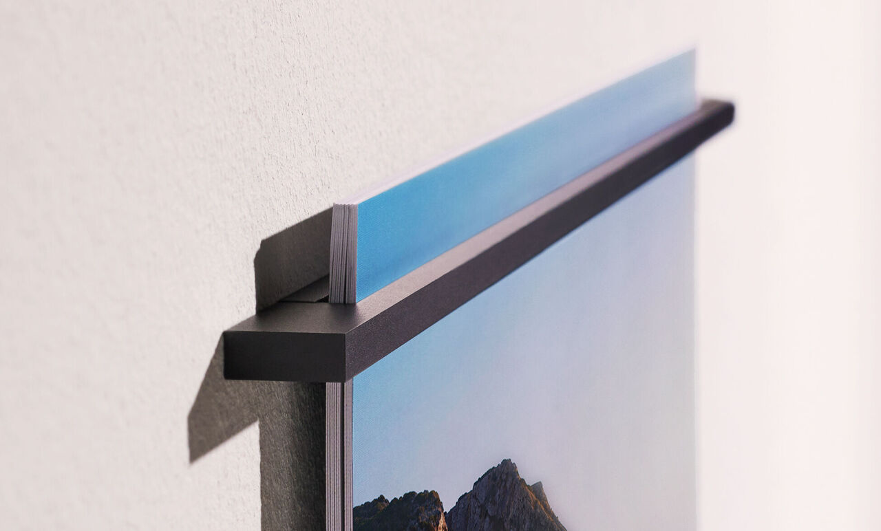 Dettaglio di un quadro appeso al muro che mostra il supporto superiore.