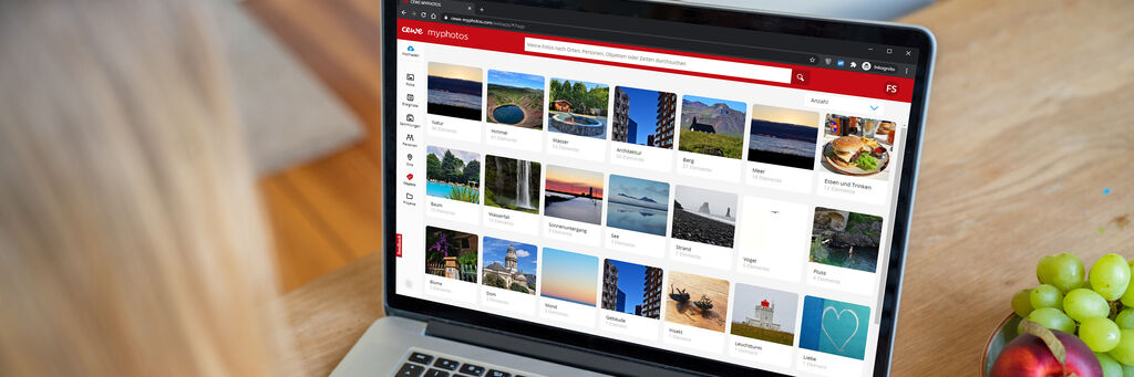 Una persona è seduta davanti a un laptop e sfoglia una galleria fotografica con immagini varie.