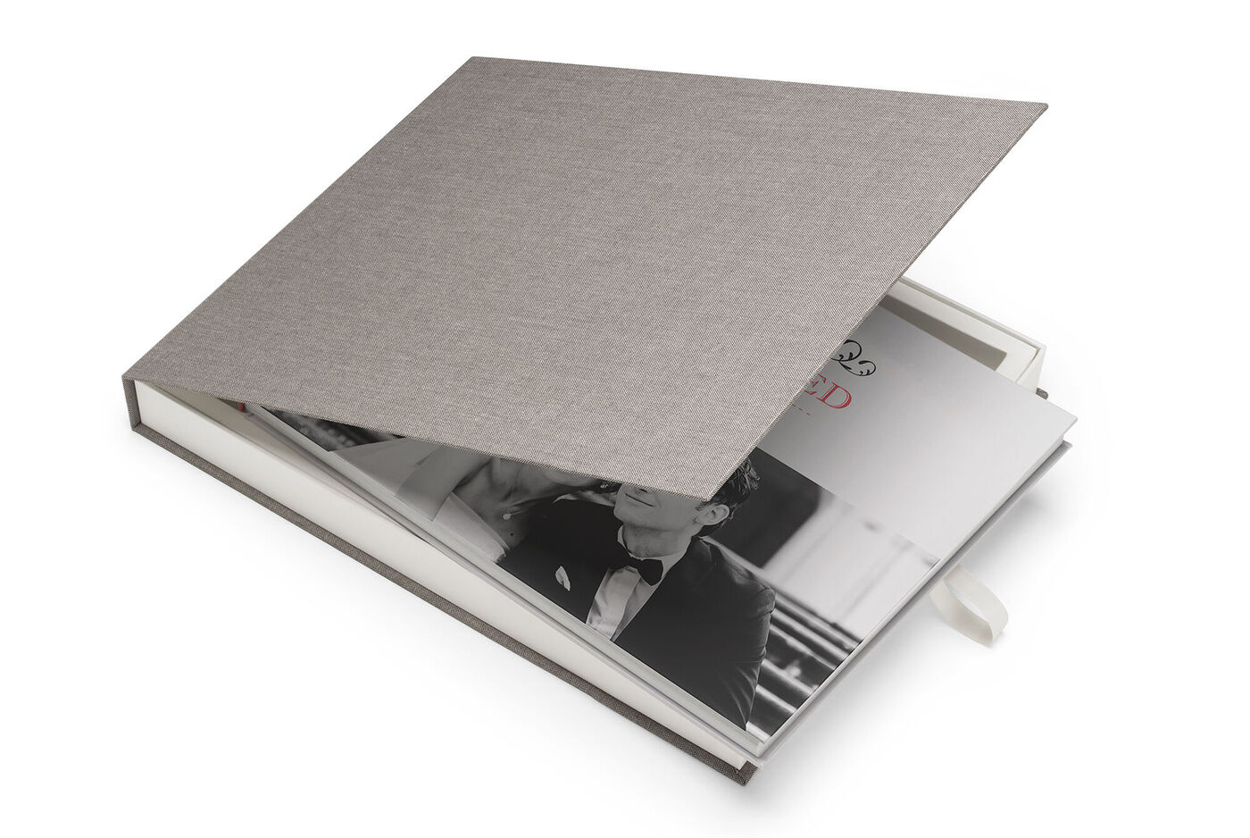 Un CEWE PHOTOBOOK aperto con una copertina rigida grigia elegante e una foto romantica in bianco e nero dentro.