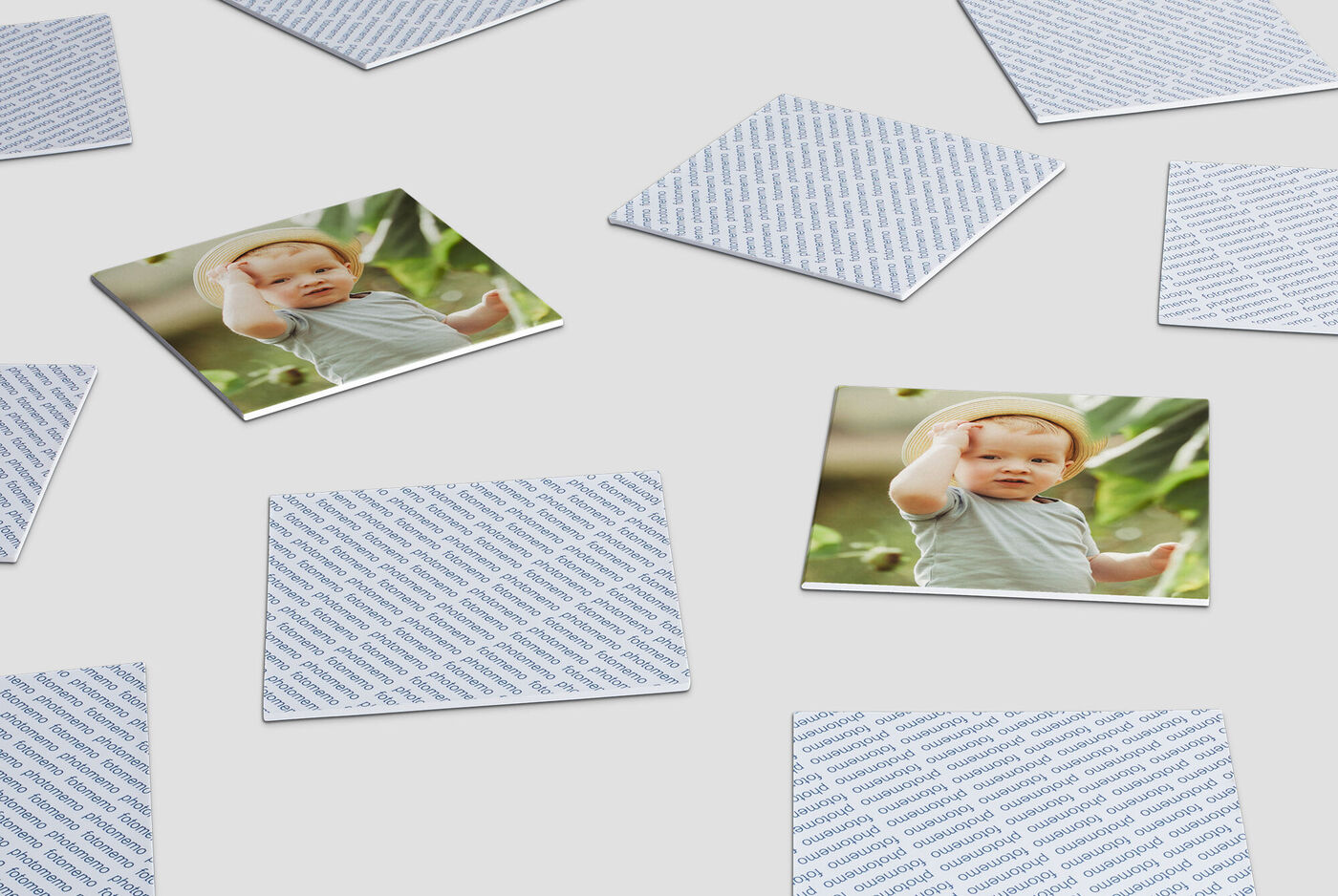 Bambino sdraiato su un pavimento di legno tra carte da gioco.