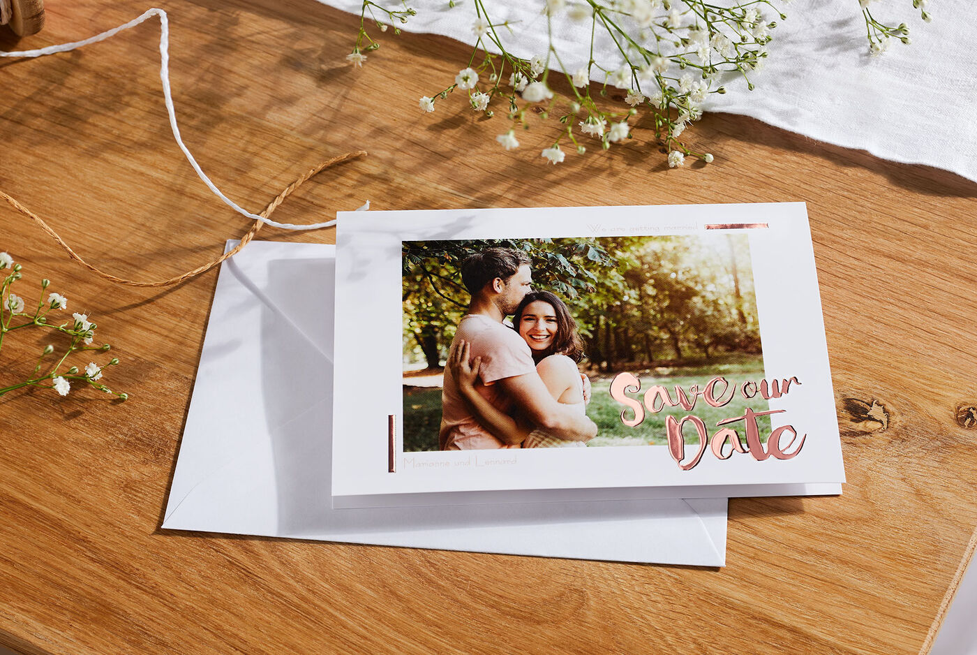 Un invito creativo con il testo 'Save Our Date', circondato da un'atmosfera amorevole e accenti floreali.