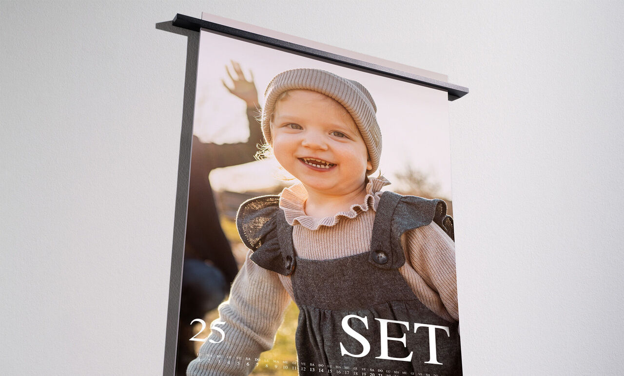 Un bambino felice con capelli castani in un abito grigio, che sorride con gioia. Sullo sfondo ci sono movimenti sfocati. Il calendario mostra maggio con il numero 25 e la parola 'SET'.