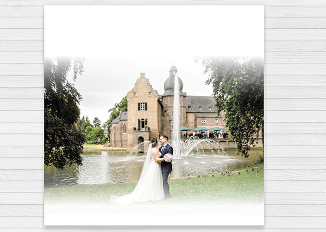 Sposa e sposo si trovano sulla riva di un lago davanti a una romantica villa storica.