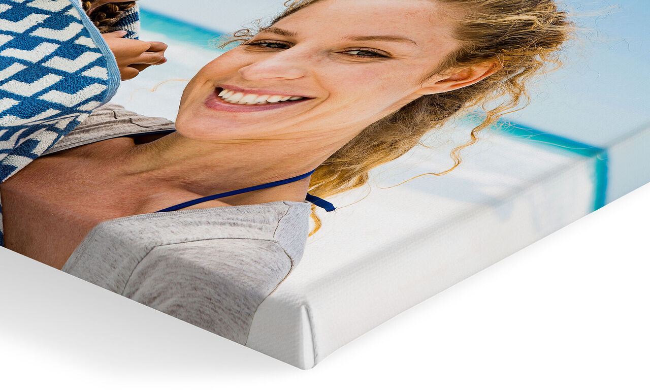 Una donna sorridente con capelli ricci davanti a uno sfondo azzurro.