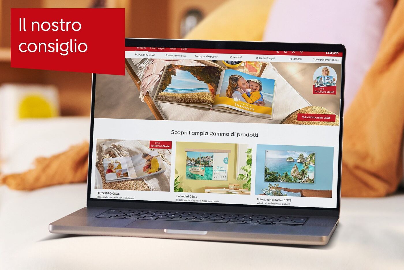 Laptop su un tavolo mostra un fotolibro CEWE e idee di design creative.