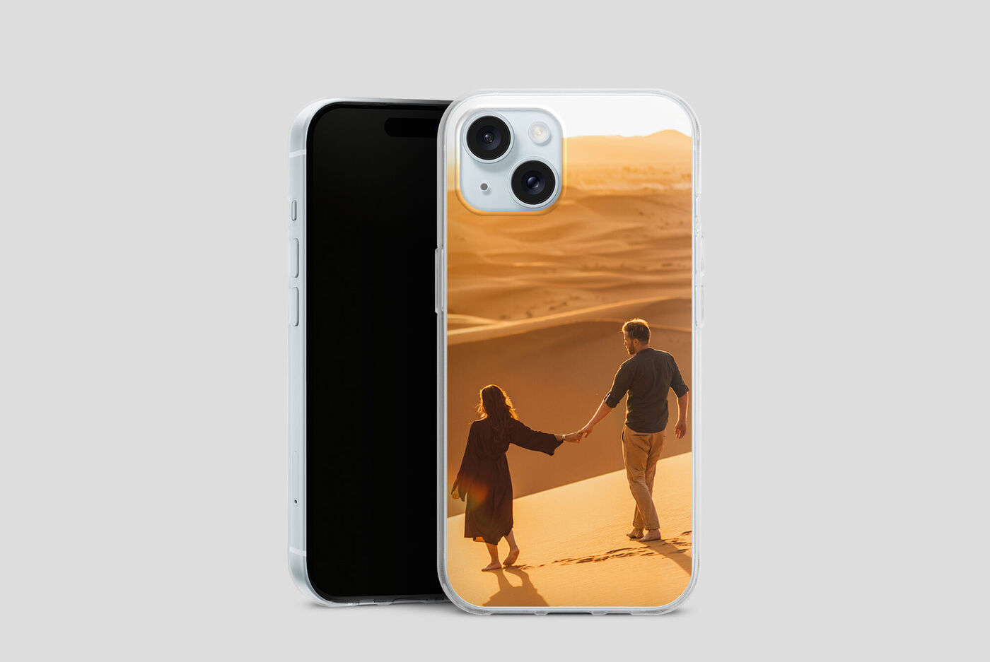 Due persone mano nella mano su un orizzonte di dune di sabbia al tramonto.