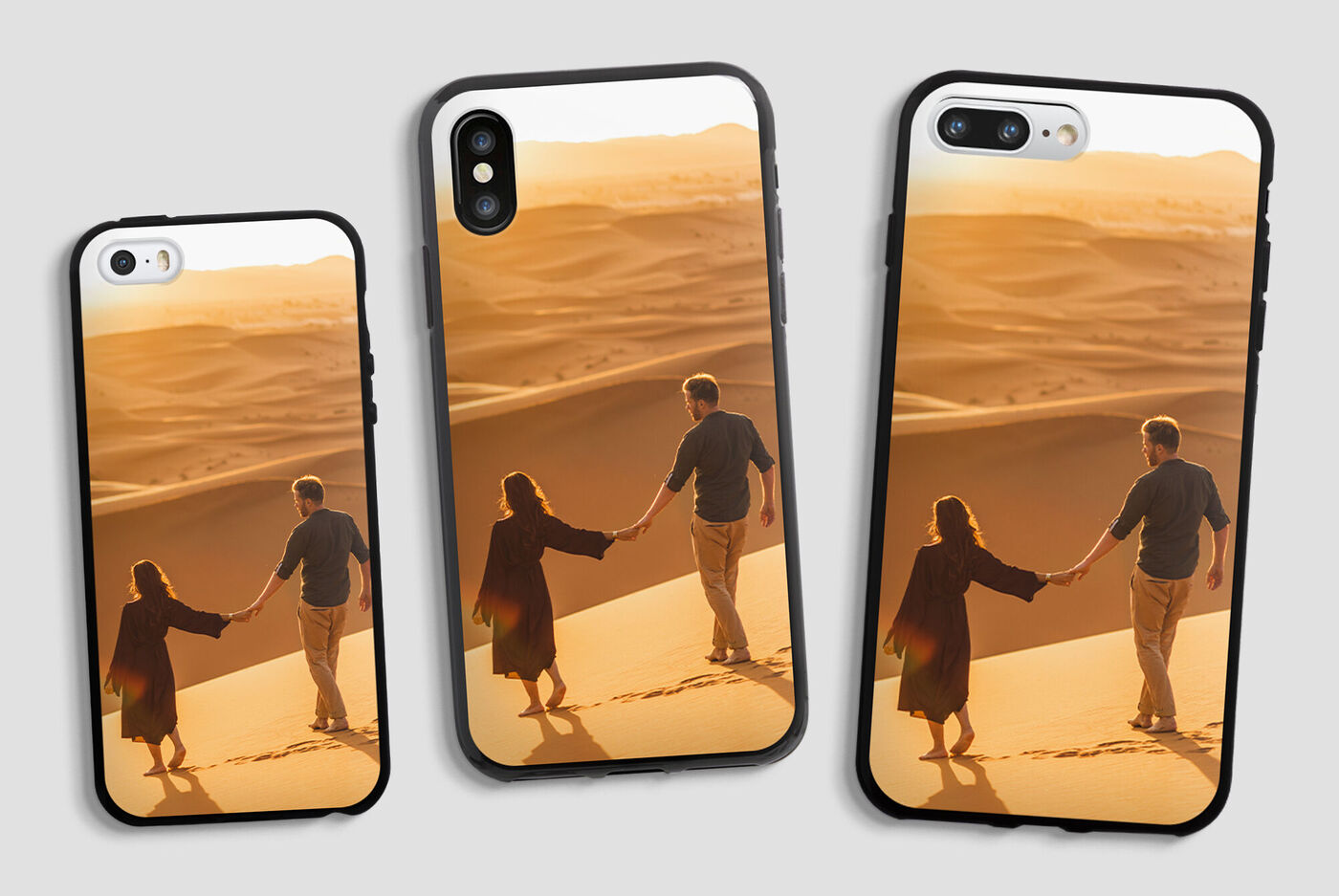 Due persone si tengono per mano su una duna di sabbia al tramonto, circondate da un deserto dorato