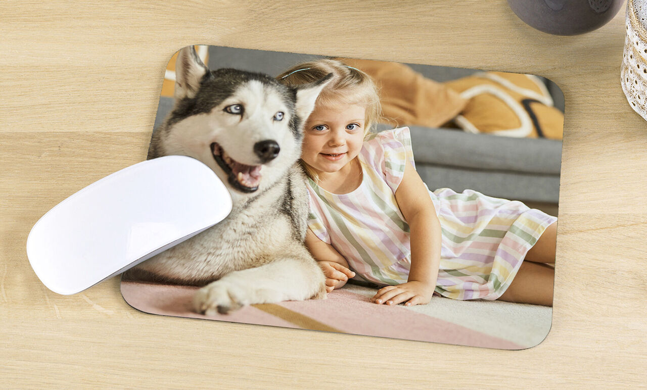 Un bambino felice giace accanto a un cane amichevole su un tappeto.