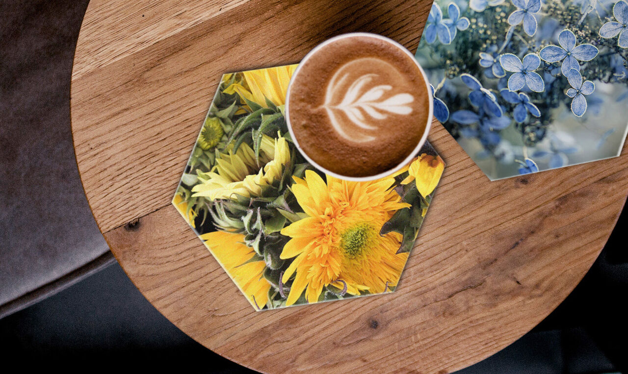 Vista splendida su una superficie in legno con un sottobicchiere esagonale e una tazza di caffè con motivo latte.
