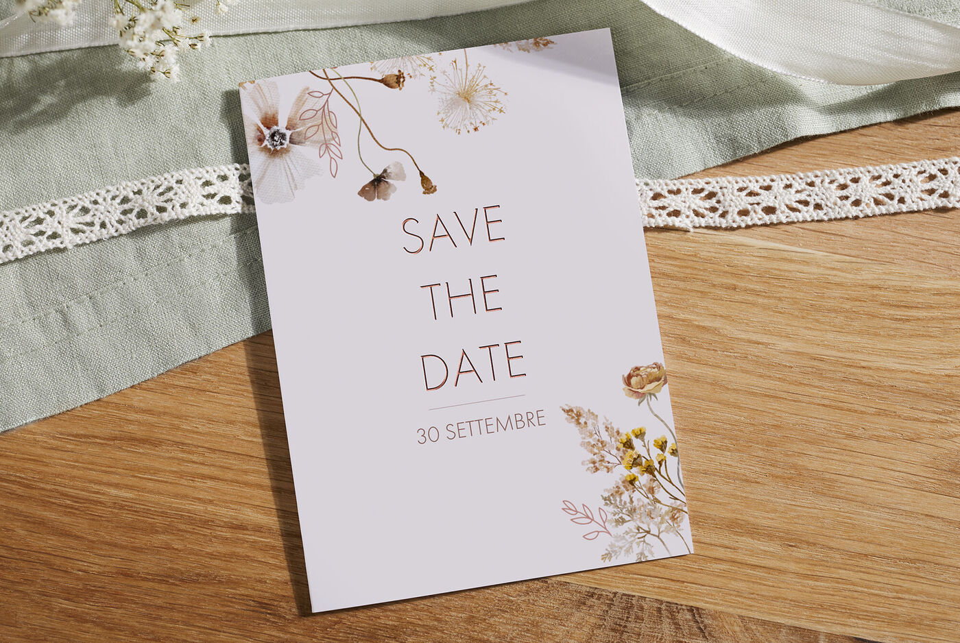 Un elegante biglietto Save-the-Date con motivi floreali in colori tenui.
