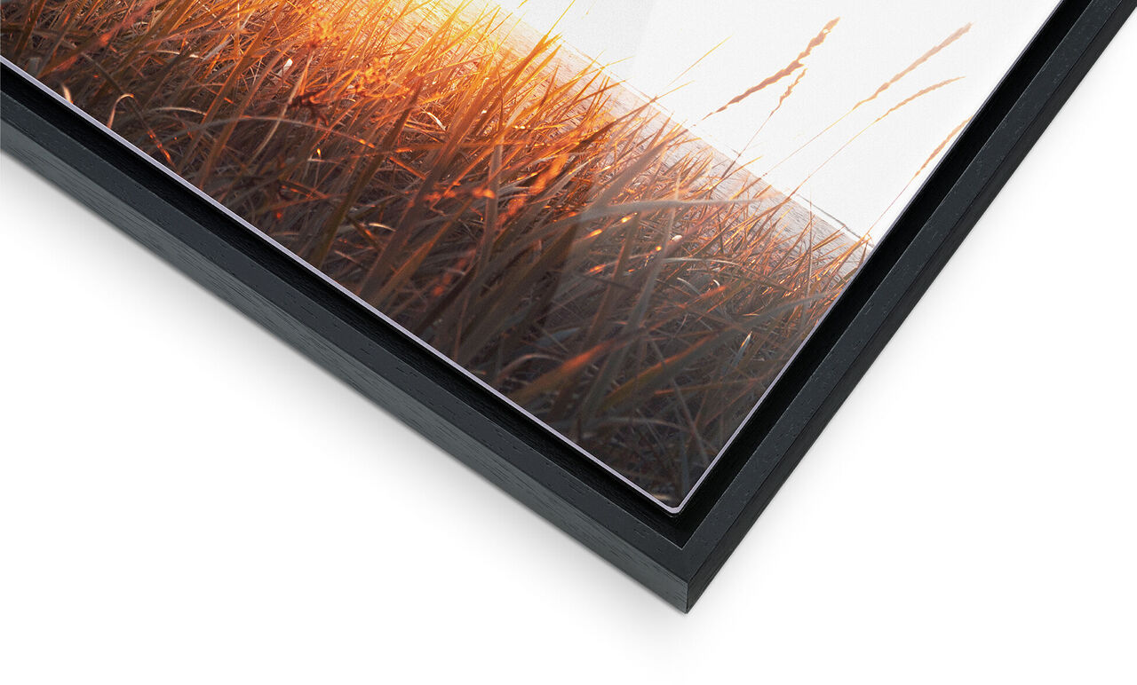 Ingrandimento di una cornice con un'immagine colorata di un tramonto sopra l'erba.