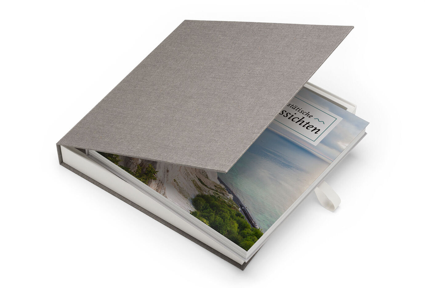 Un elegante CEWE PHOTOBOOK con copertina in tessuto grigio e finestra che mostra una foto di paesaggio.