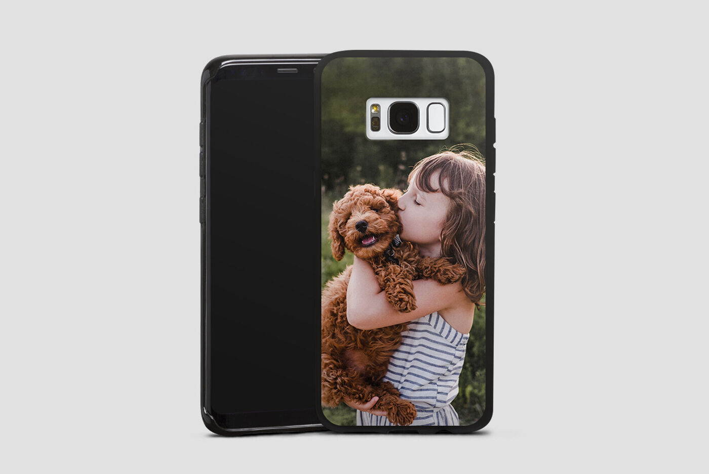 Un bambino felice tiene un cane tra le braccia e sorride.